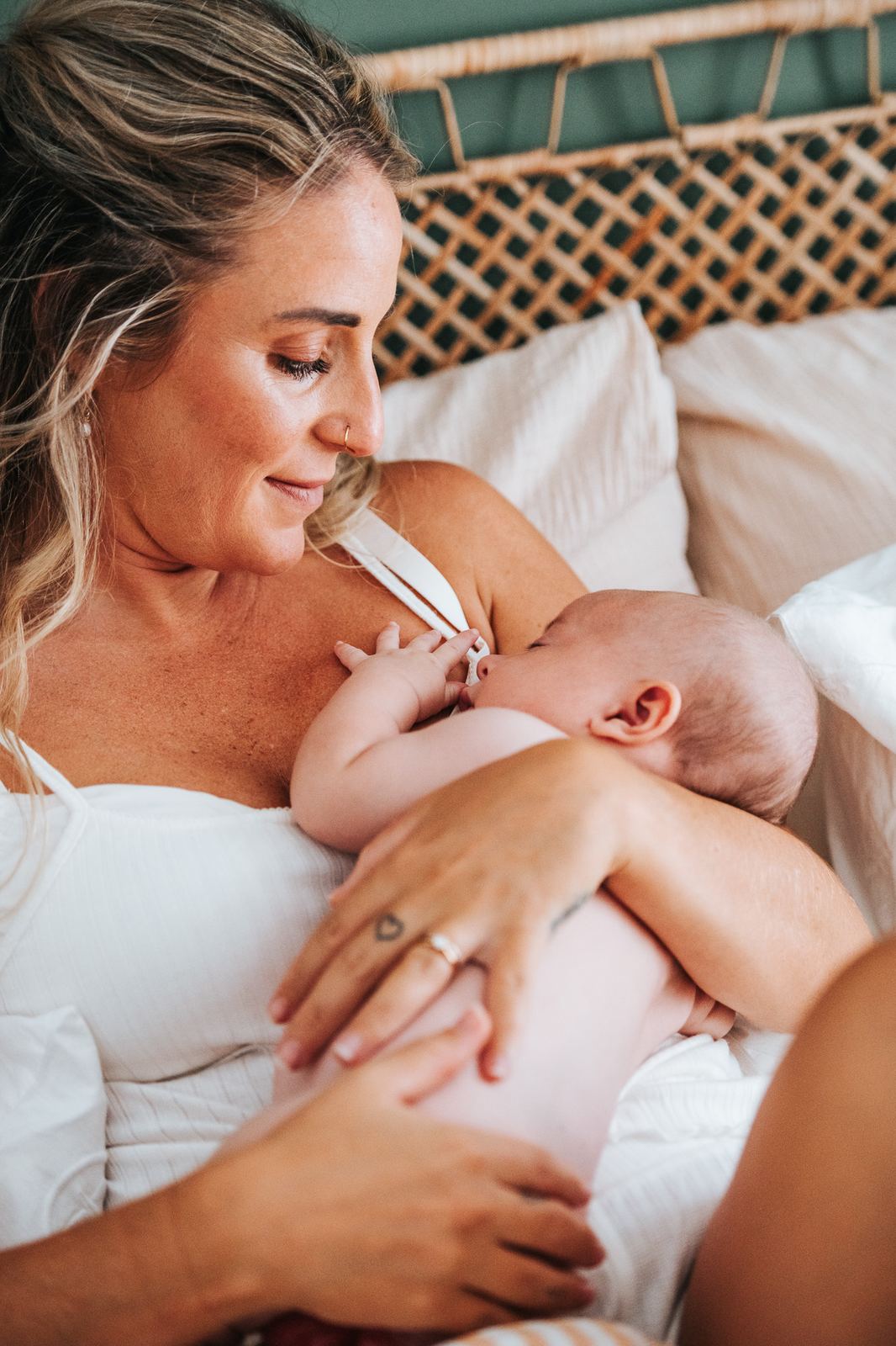 Maman qui allaite son bébé, cadrage doux sur les mains et le regard