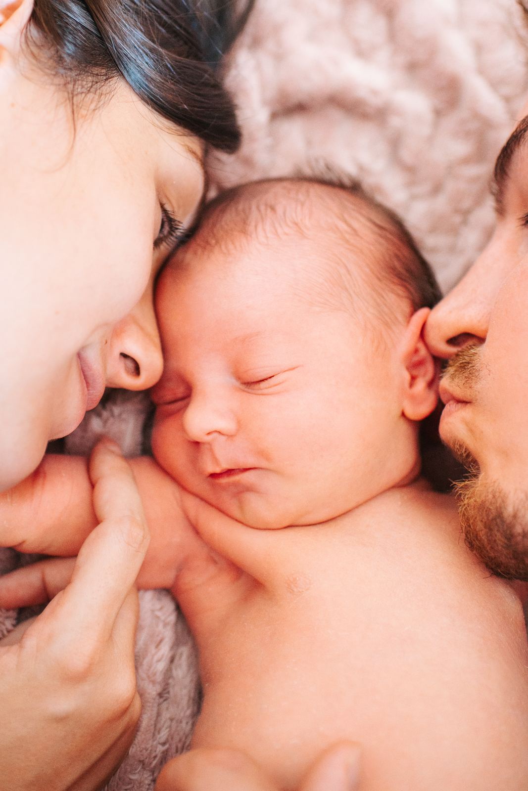 Parents joue contre joue avec leur bébé endormi