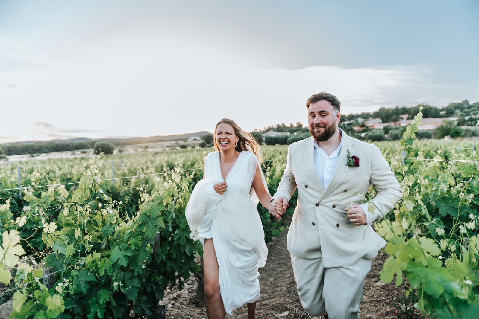 Mariés qui marchent dans les vignes en riant