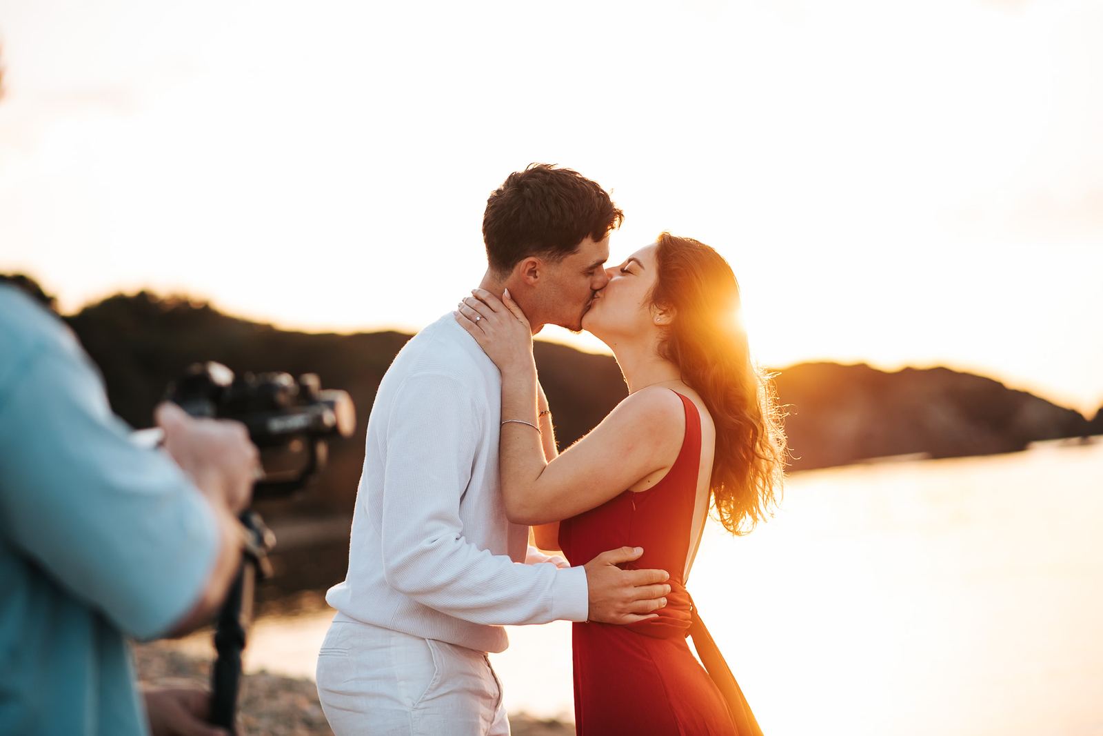 Tournage vidéo d'un baiser au coucher du soleil face à la mer