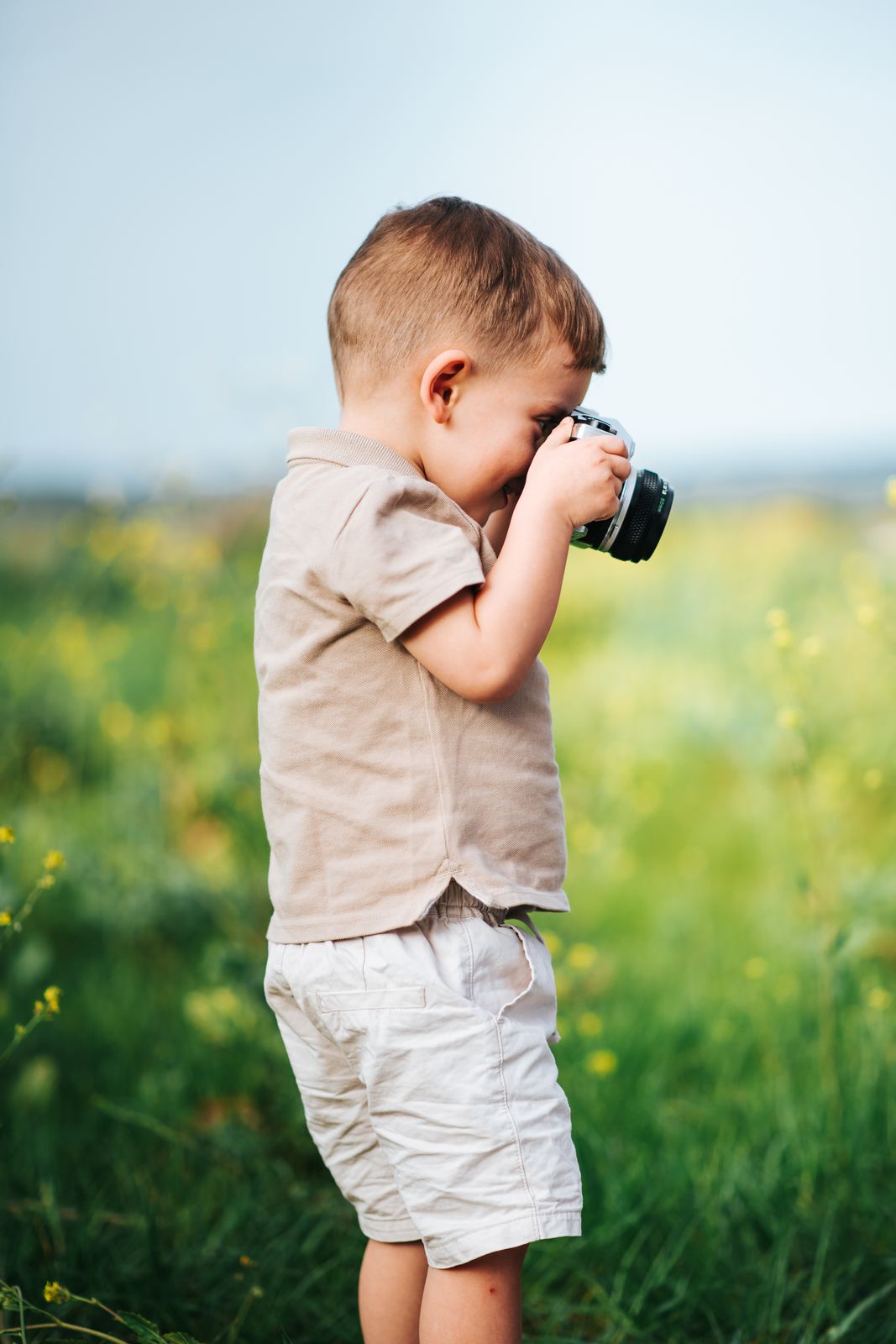 Petit garçon qui joue au photographe avec un appareil photo