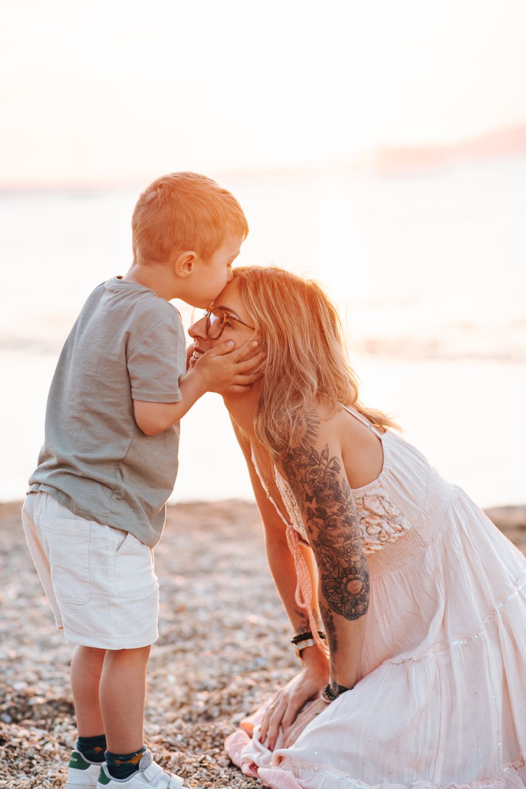 Petit garçon qui embrasse sa maman sur la plage