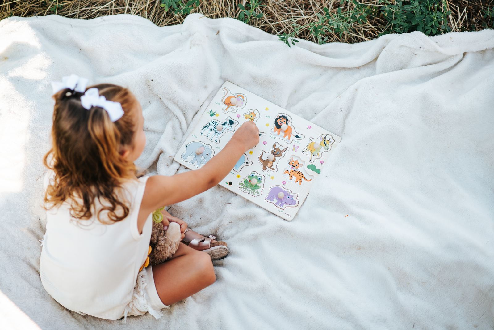 Petite fille qui lit un livre sur une nappe de pique-nique