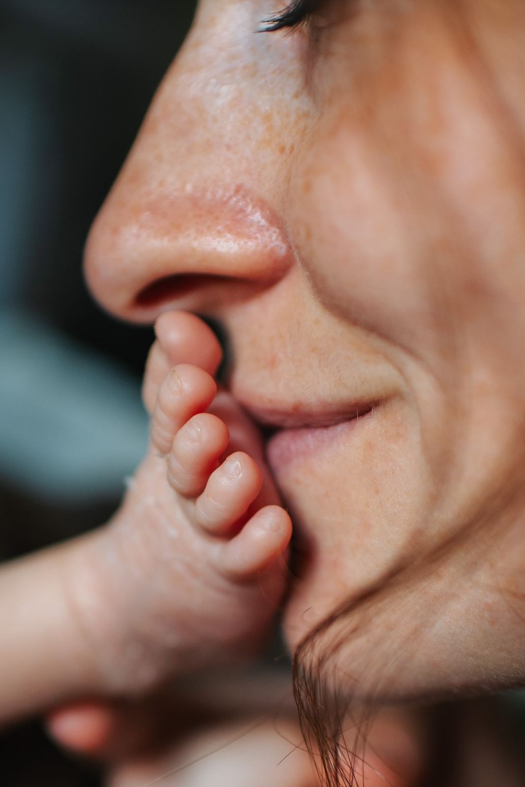Maman qui embrasse le petit pied de son bébé