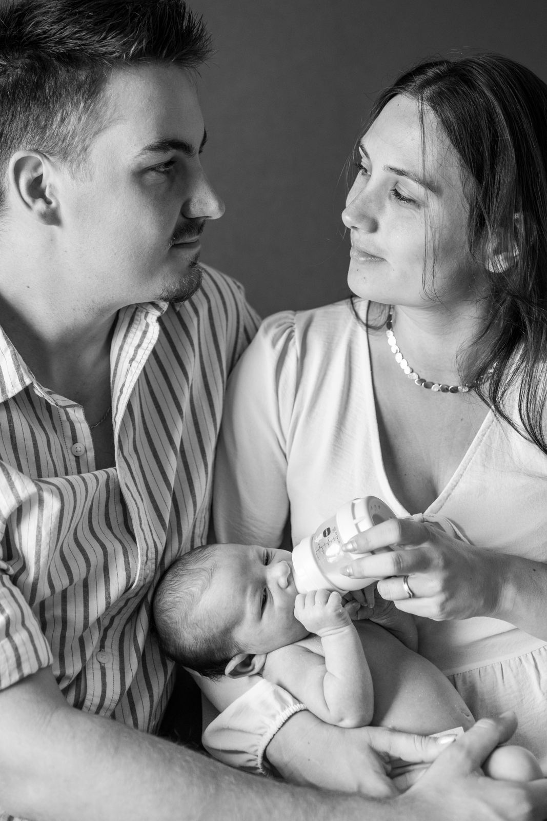 Parents qui regardent leur nouveau-né, en noir et blanc