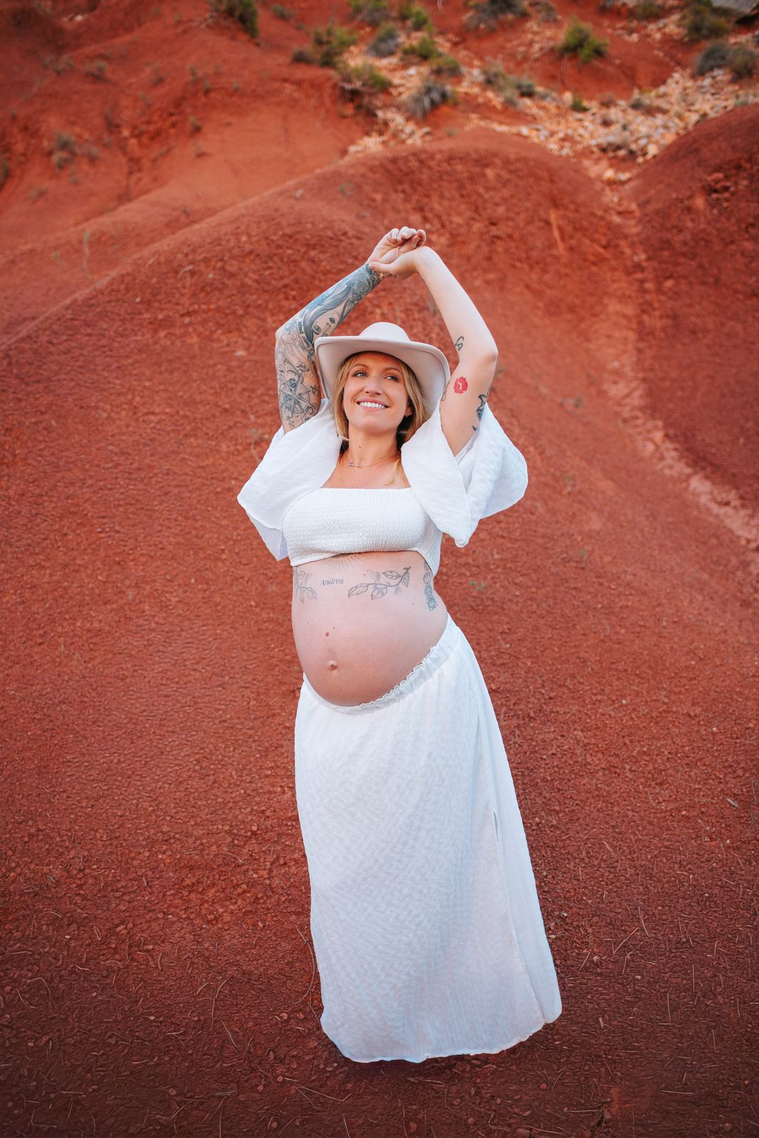 Future maman en robe blanche au milieu des ocres rouges de Provence