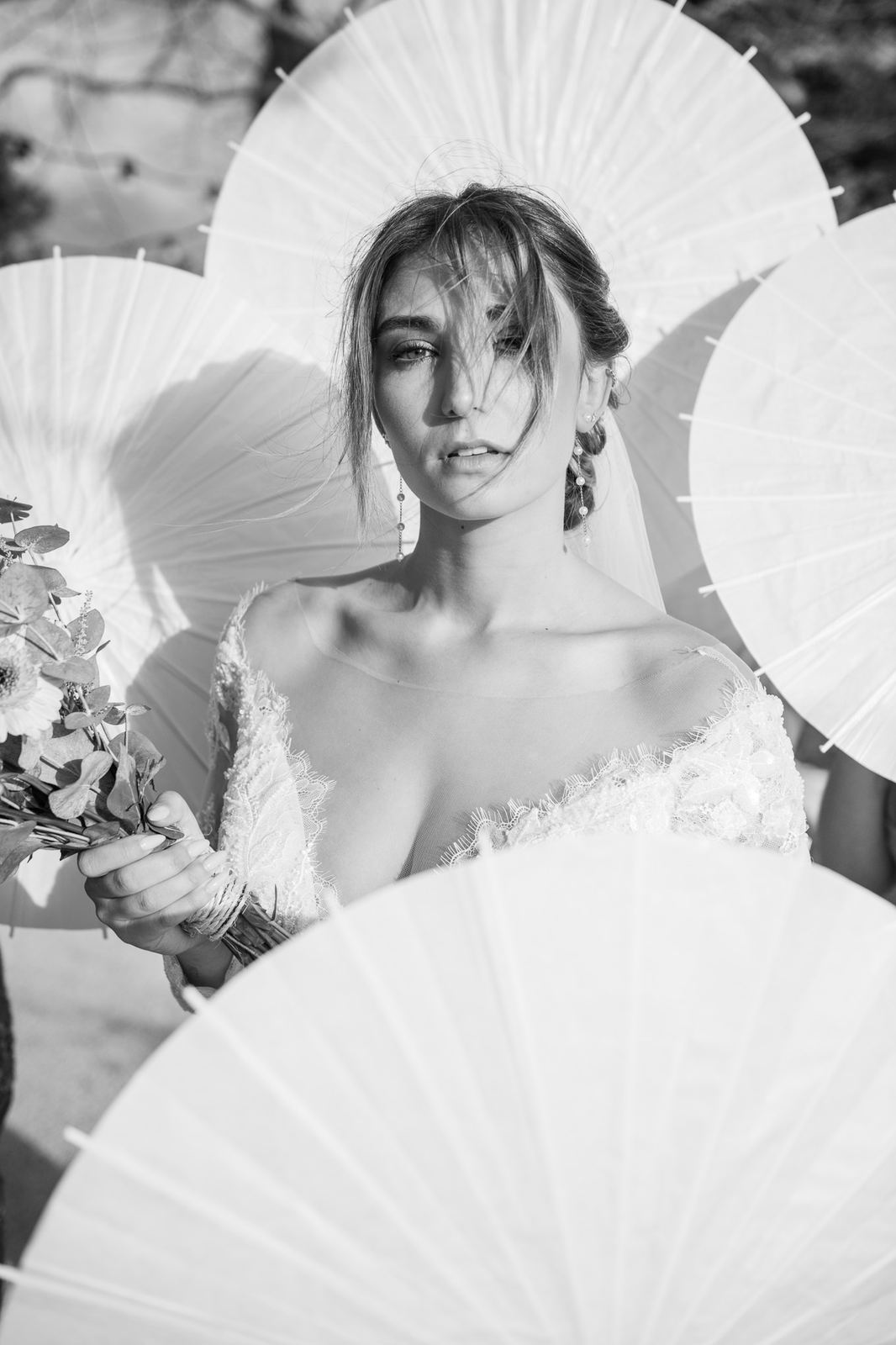 La mariée entourée d'ombrelles blanches, en noir et blanc