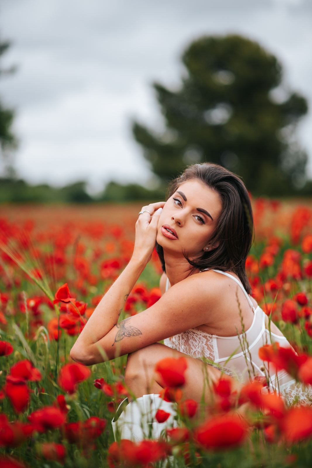 Portrait dans les coquelicots sous un ciel couvert