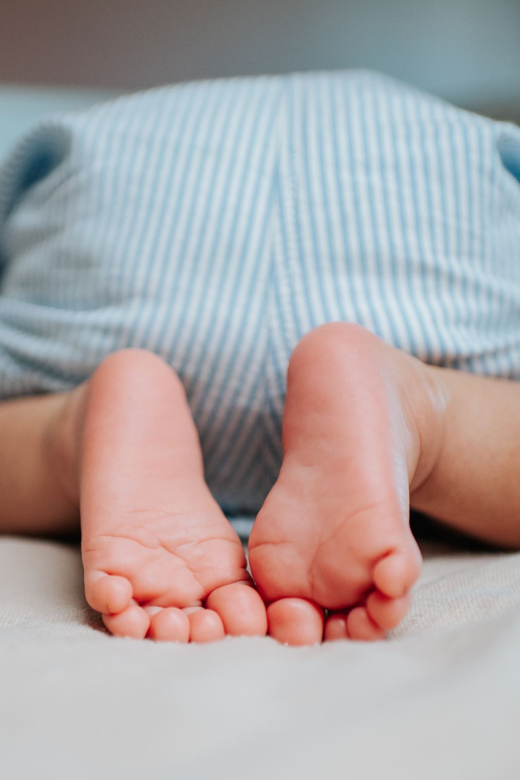 Petits pieds de bébé sur un drap clair
