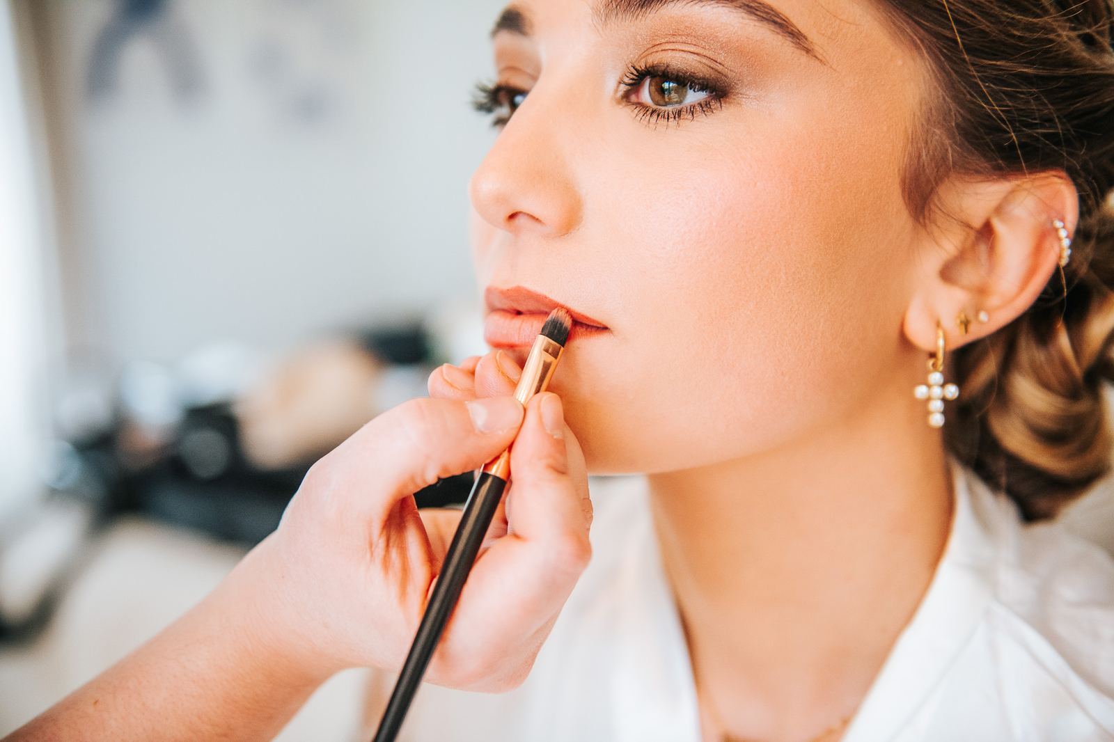 Maquillage de la mariée, gros plan sur le pinceau et les lèvres