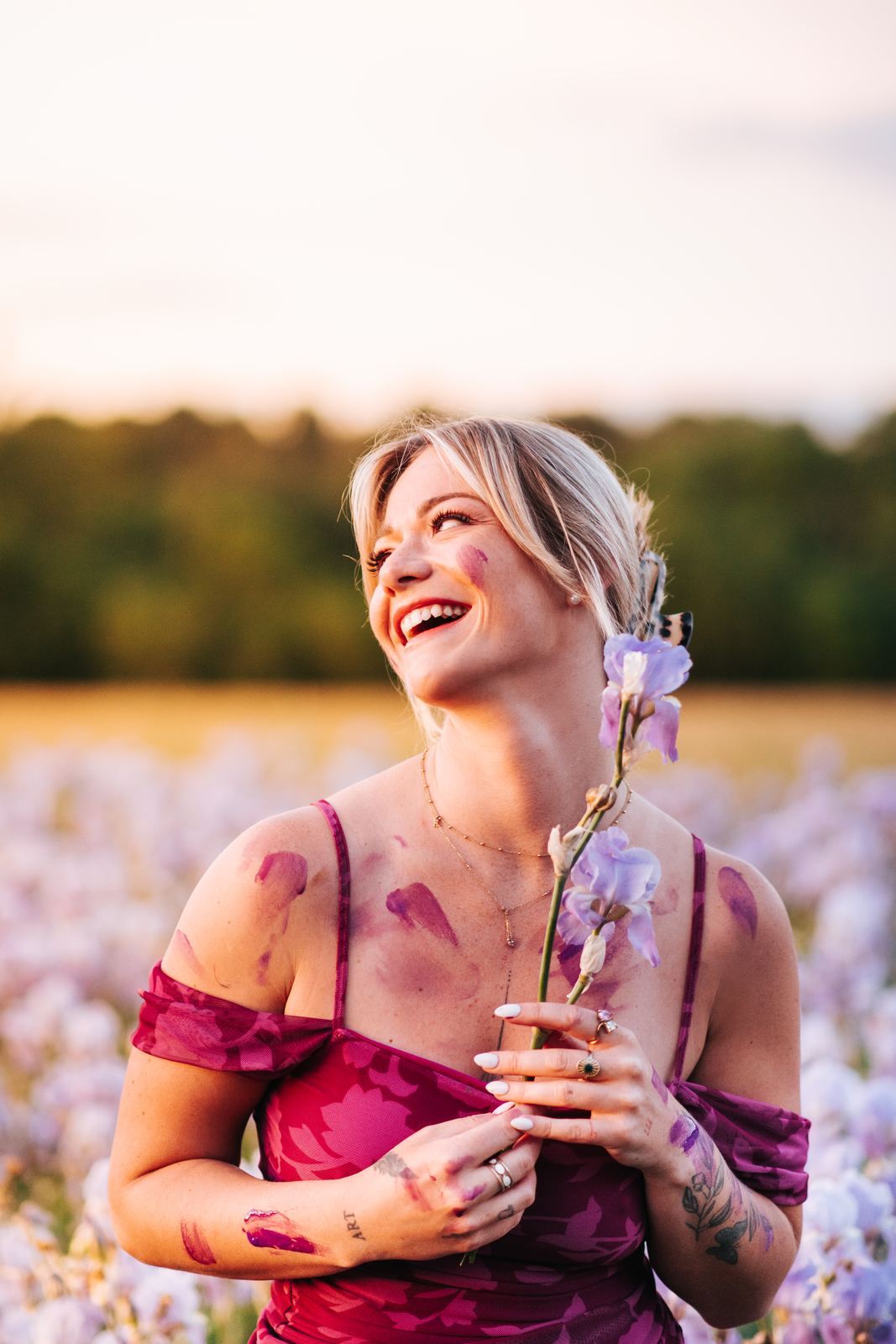 Femme qui rit, une fleur d'iris à la main