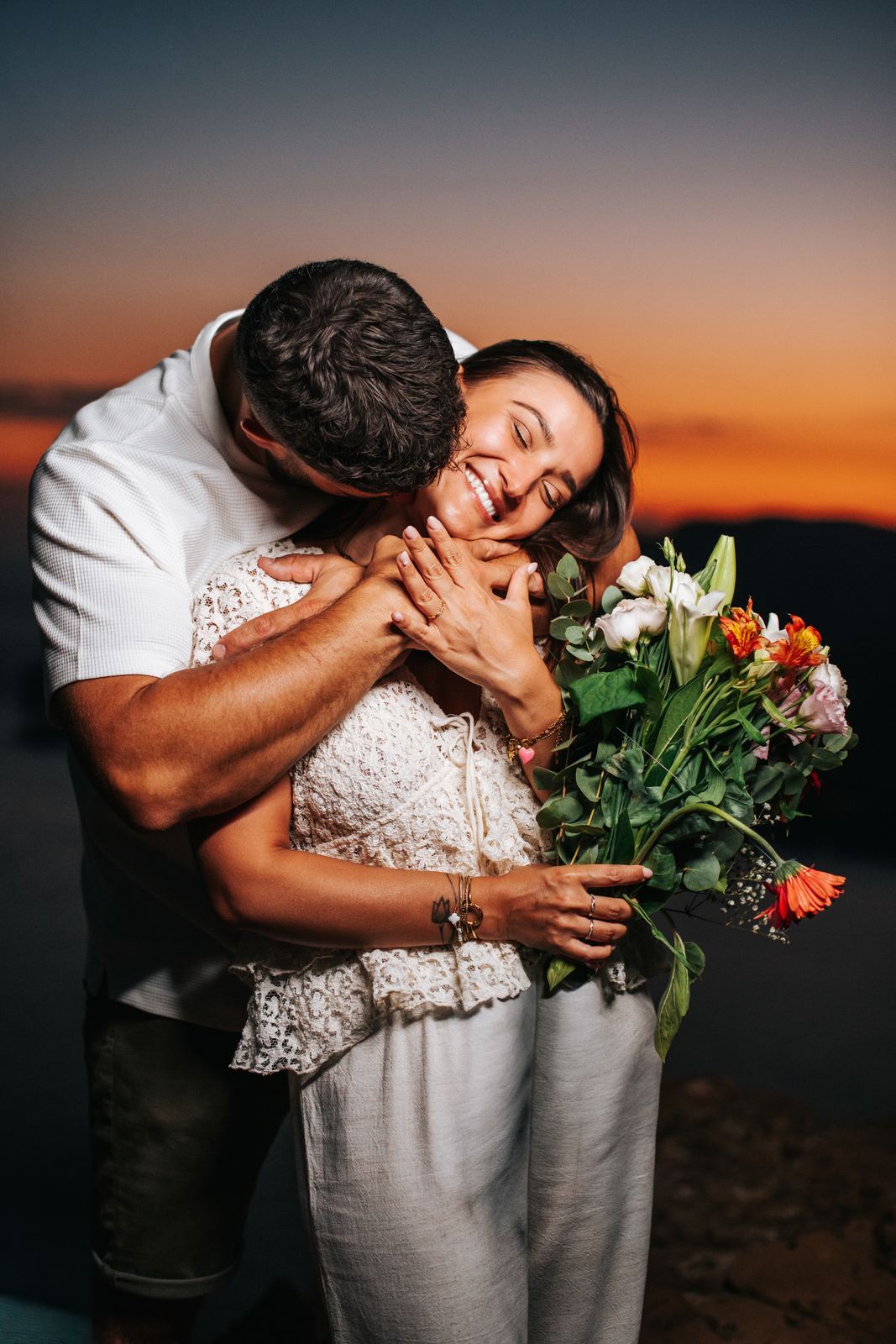 Couple enlacé juste après le coucher du soleil, ciel orangé