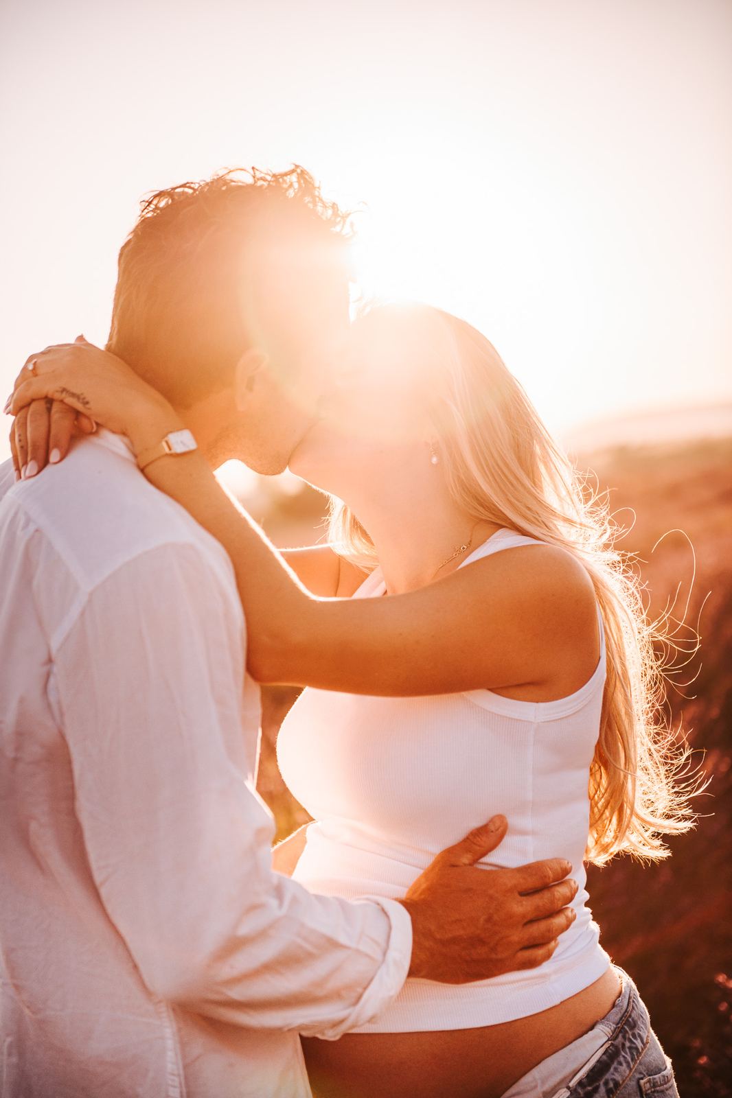Couple qui s'embrasse dans la lavande au coucher du soleil