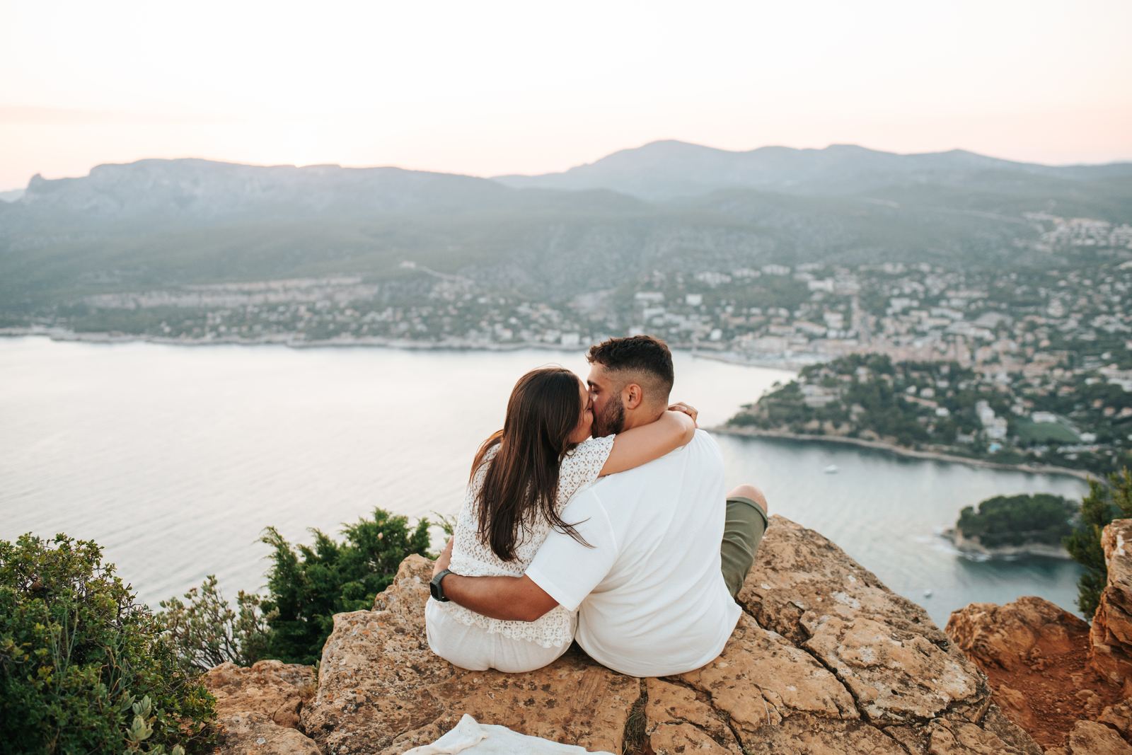 Couple assis sur les rochers face à la baie de Cassis