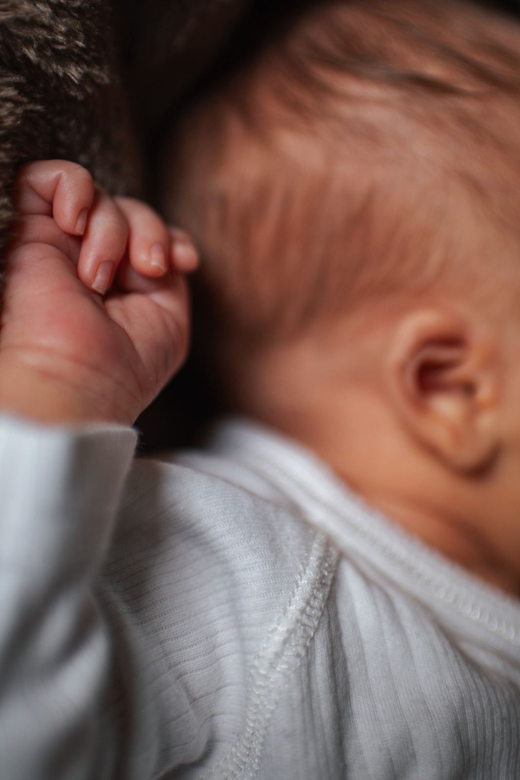 Gros plan sur la petite main repliée d'un nouveau-né endormi
