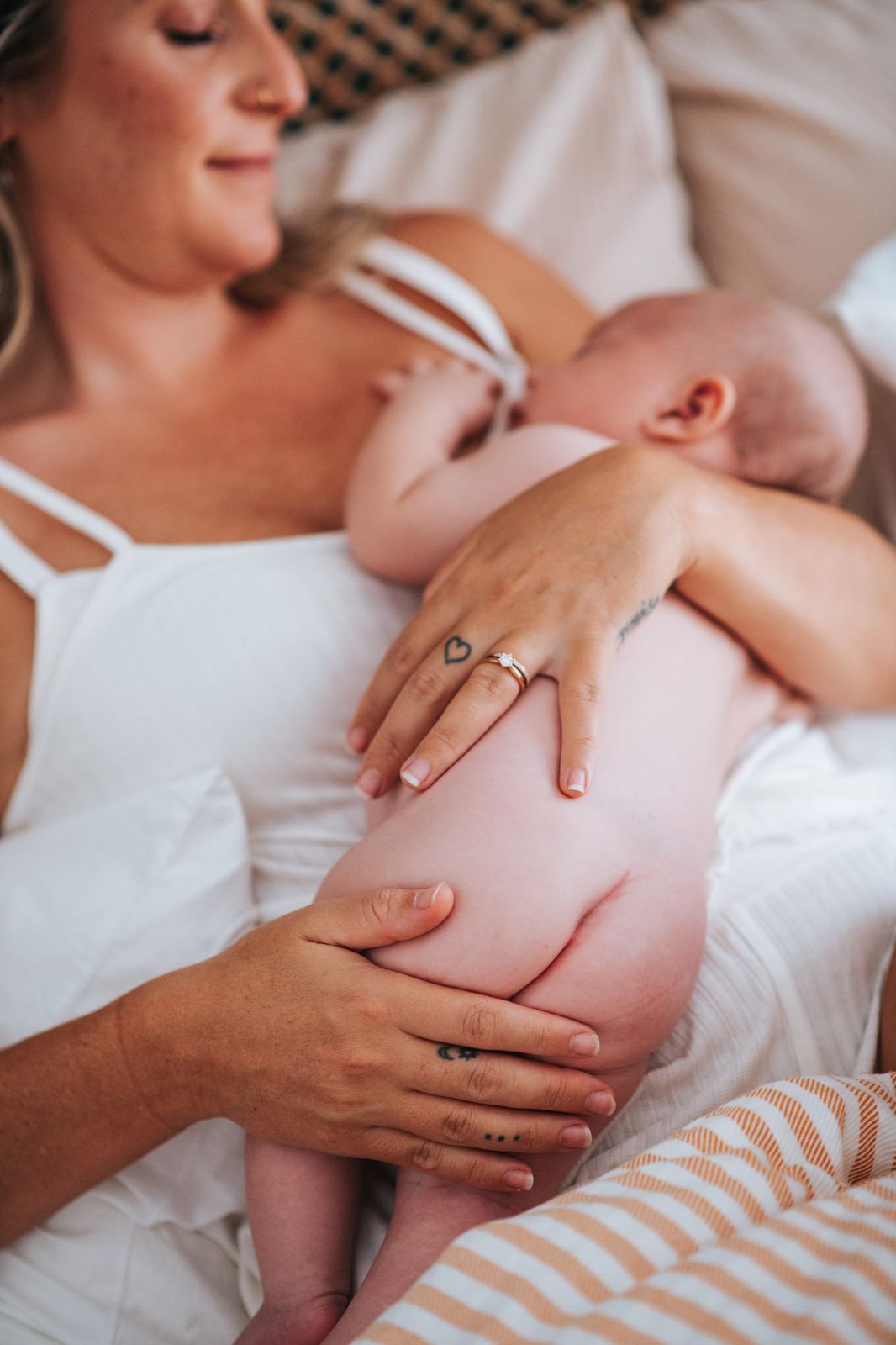 Maman qui allaite son bébé sur le lit, cadrage pudique