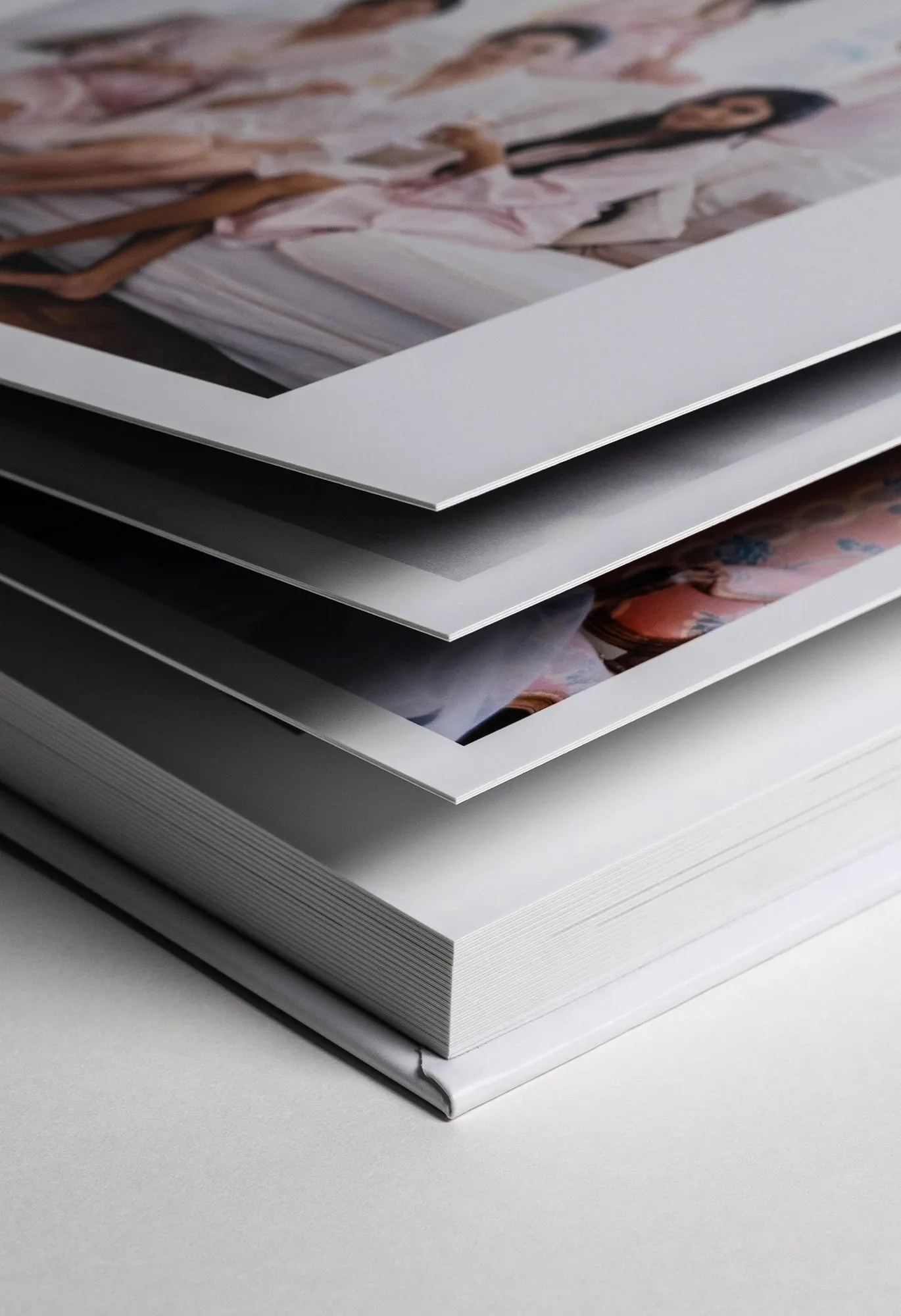 Album de mariage en gros plan : pages épaisses imprimées de photos, posées sur une couverture blanche