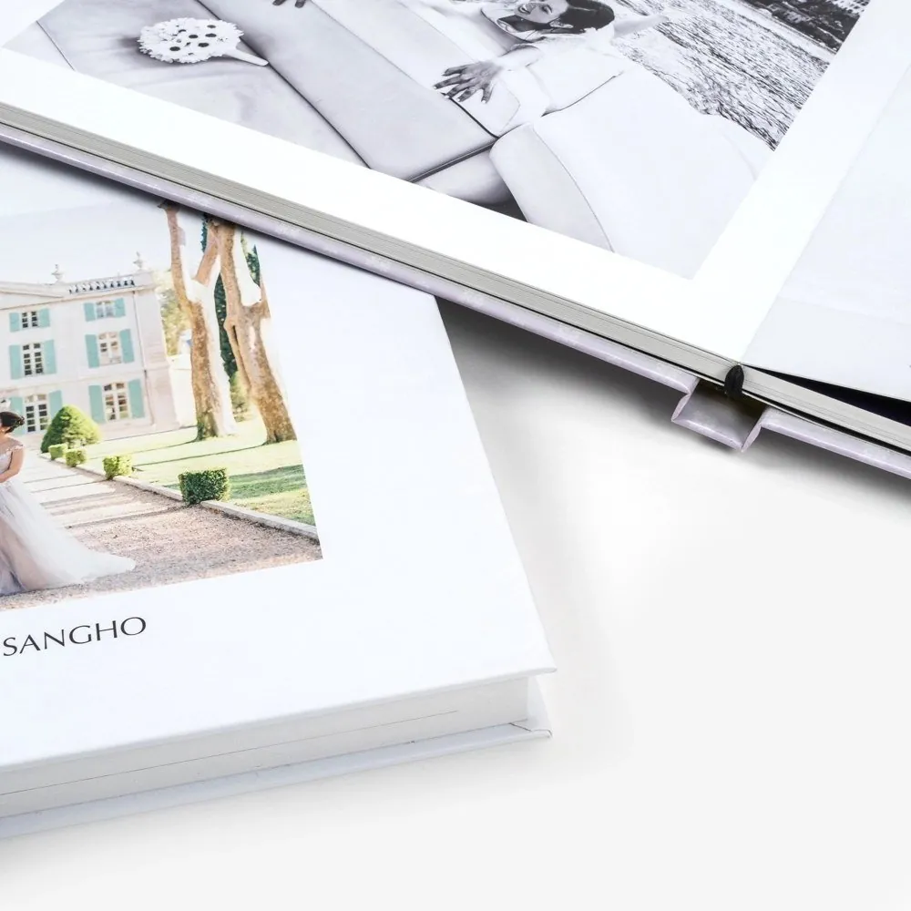 Albums photo de mariage ouverts, avec une mariée devant une bastide et un portrait de couple en noir et blanc