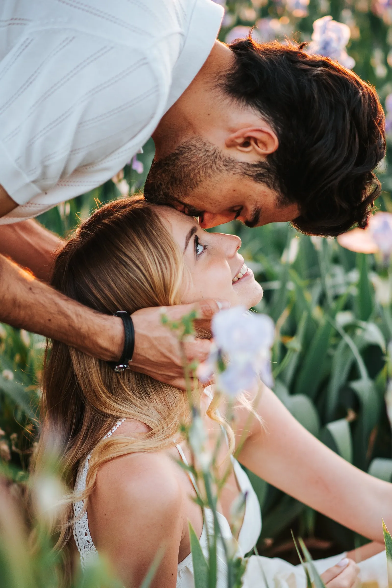 Il dépose un baiser sur son front pendant qu'elle lève les yeux vers lui en souriant, au milieu des iris, à Cassis
