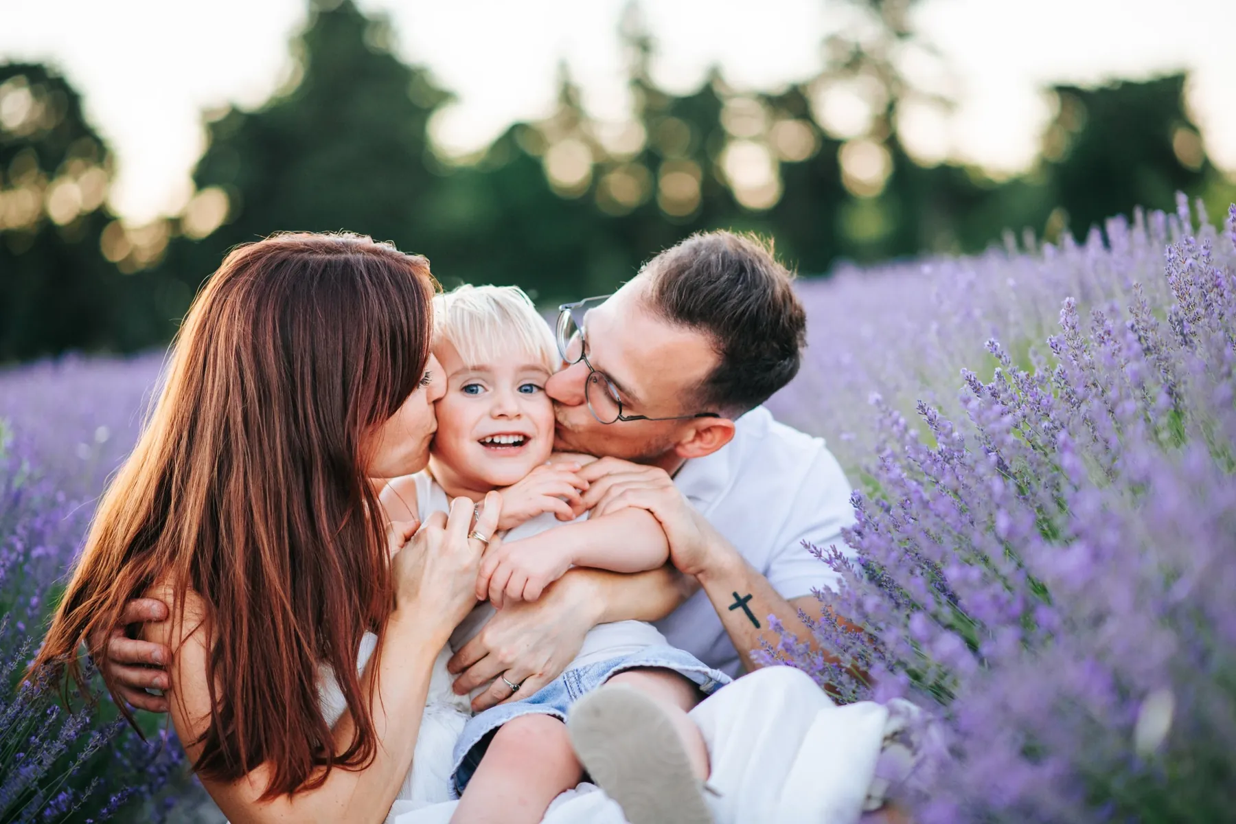 Maman, papa et leur fille, joue contre joue dans la lavande