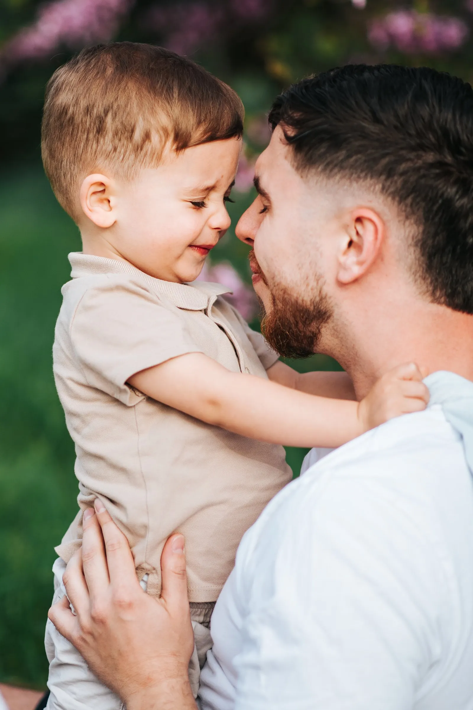 Father and son bond: a dad and his little boy nose to nose, giggling during a family session