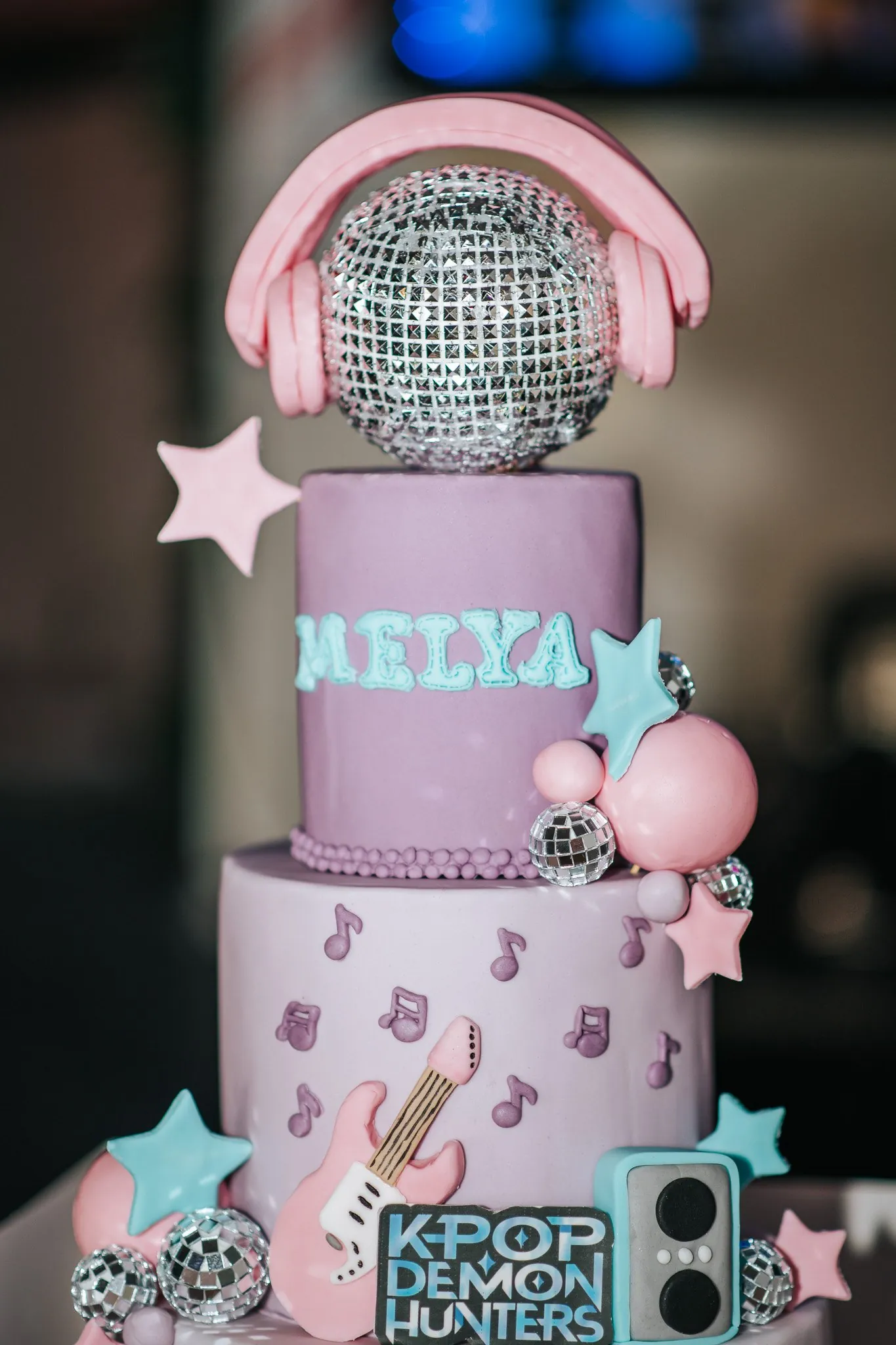 Gâteau d'anniversaire à étages thème K-pop : boule disco, casque rose, guitare et notes de musique en pâte à sucre