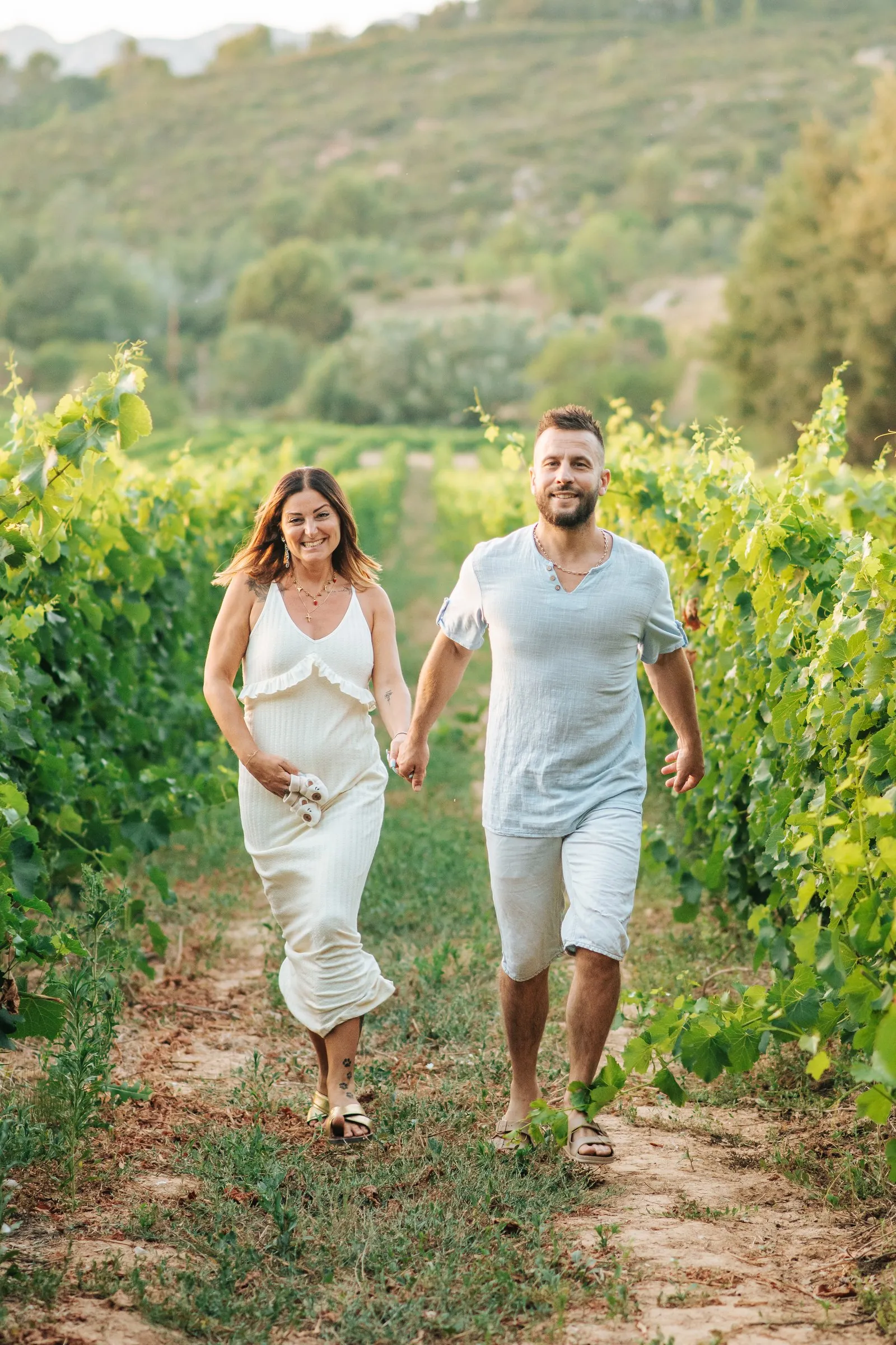 Mariage dans le Var : les mariés marchent en riant dans les vignes d'un domaine
