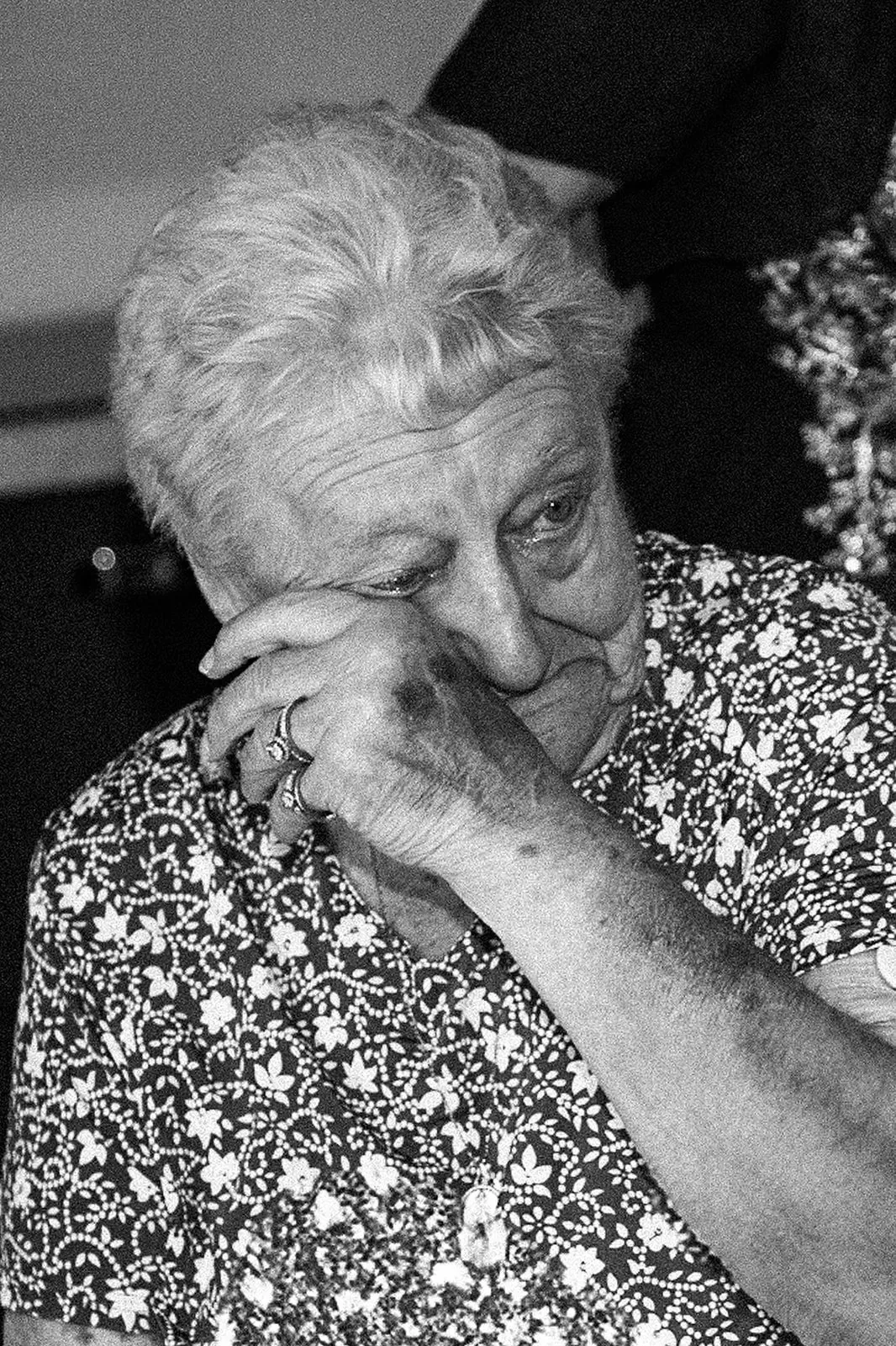 Émotion au mariage : une grand-mère essuie une larme pendant la cérémonie, portrait en noir et blanc