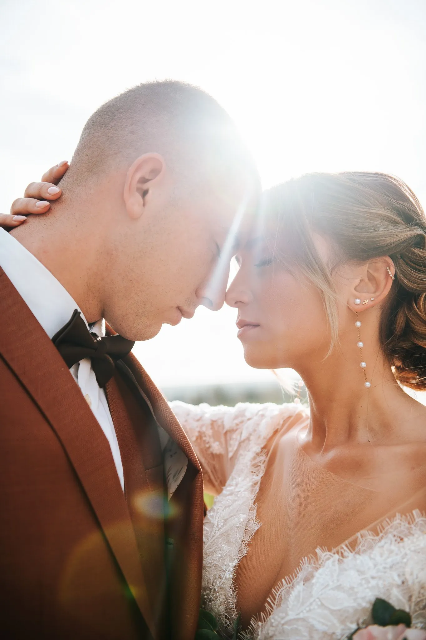 Mariage dans les Alpilles : les mariés s'embrassent entre les oliviers et un grand pin