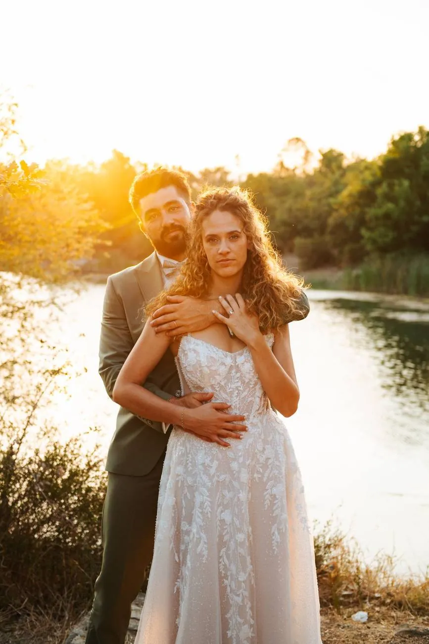 Mariage en Provence : le marié enlace la mariée au bord de l'eau, au coucher du soleil