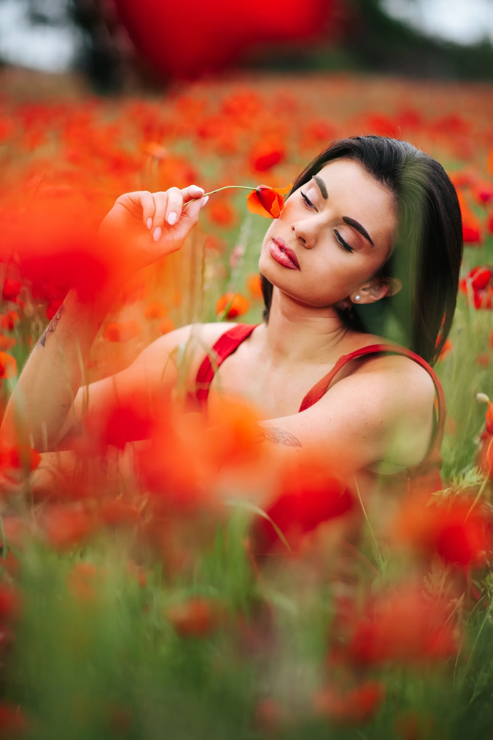 Séance portrait dans un champ de coquelicots près de Montpellier, une fleur à la main