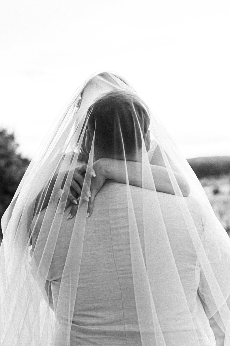 Photographe fine art mariage – couple de dos en noir et blanc sous un voile