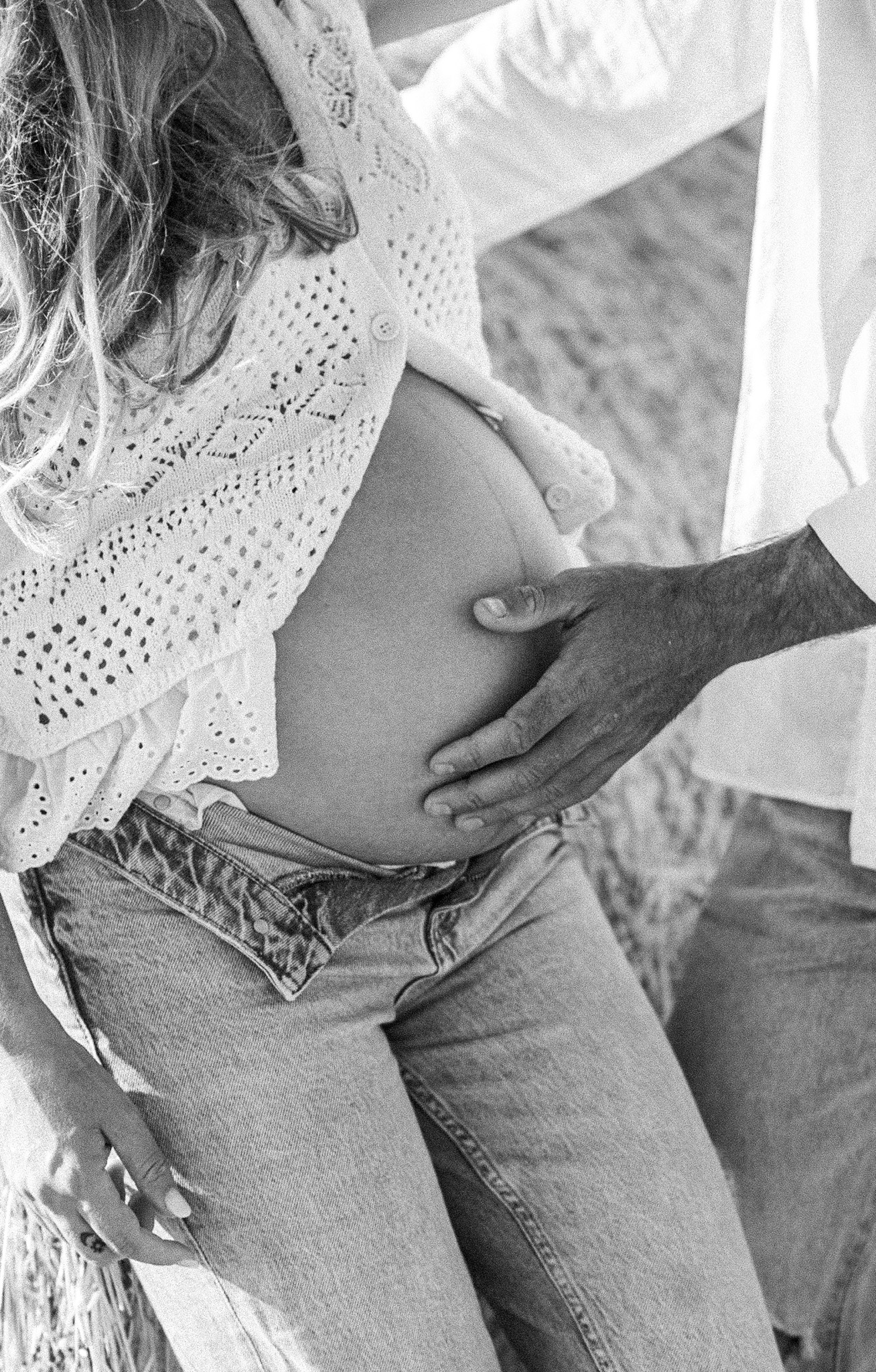 Détail des mains du couple sur le ventre, photo grossesse